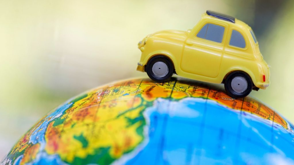 a yellow toy card placed on a globe represents video distribution around the world