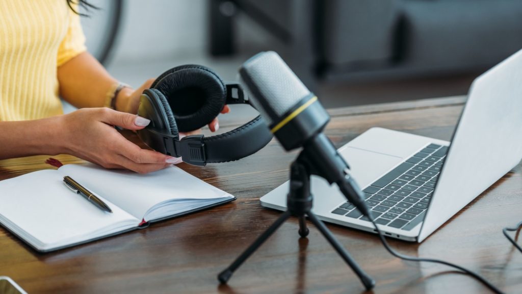 woman with a laptop, mic, and headphones