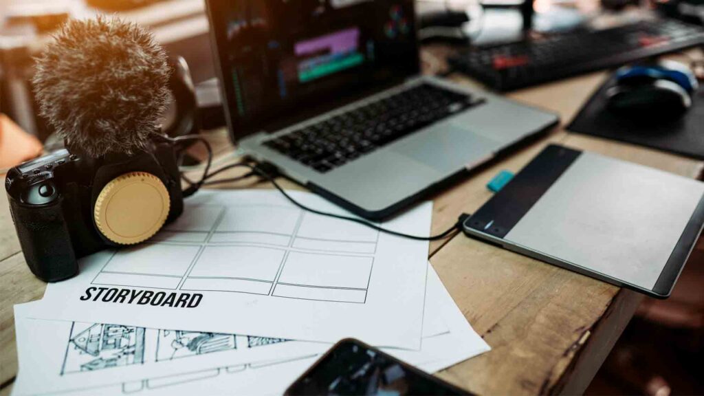 A video storyboard and video production equipment laid out on a desk